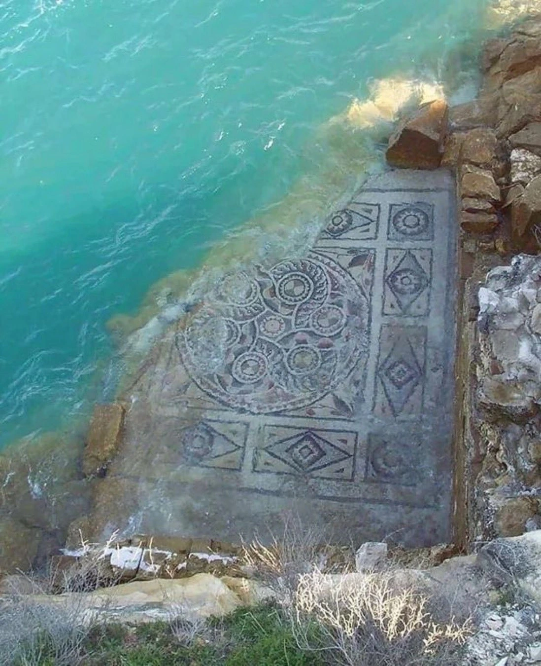 Ancient Roman mosaic partially submerged under the tide